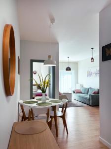Una cocina y una sala de estar con mesa y sillas. en Apartament Mona Jeżyce, en Poznan
