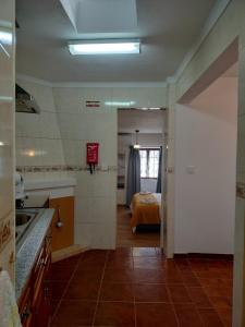 a kitchen with a sink and a bed in a room at Stone House in Oliveira do Hospital