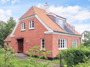 a red brick house with a balcony on top of it at 6 person holiday home in Ålbæk in Ålbæk