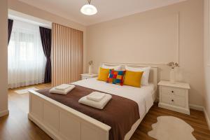 a bedroom with a large bed with two towels on it at Mid Velvet Apartment, Free Parking, Self Check-in in Oradea