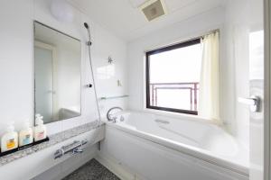 a white bathroom with a tub and a window at Hotel BELLMARE ホテルベルマーレ in Maizuru +35 photos