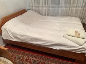 Una cama con sábanas blancas y una almohada. en Aport 24, en Karakol 8 fotos más