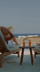 une femme allongée sur une chaise sur la plage avec une table dans l'établissement Seadream Villa, à Lakhania 59 autres photos