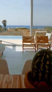 une pièce avec deux chaises et une table avec une pastèque dans l'établissement Seadream Villa, à Lakhania
