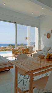 une salle à manger avec une table et des chaises en bois dans l'établissement Seadream Villa, à Lakhania