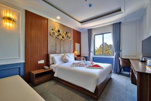 a hotel room with a large bed and a desk at S79 Happy 88 Tran Hung Dao Street in Phu Quoc