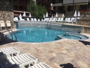 a swimming pool with white chairs and a swimming pool at Maria-Antoaneta Residence in Bansko