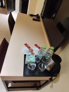 Una mesa con botellas de agua y platos encima. en Hotel Soni Mansion Pratunam, en Bangkok