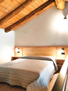 a bedroom with a bed with a wooden ceiling at ai Parlenti 25 - openspace in Tirano