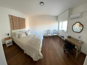 a bedroom with a bed and a desk and a mirror at Frente al mar in Montevideo
