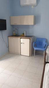 a kitchen with a counter and a blue chair at Green Forest in Berat +7 photos