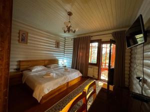 a bedroom with a bed and a television in a room at ProLes Burabay Eco Hotel in Borovoye