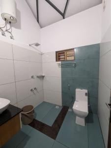 a bathroom with a toilet and a sink at Vayalil Homestay in Karuvārakundu