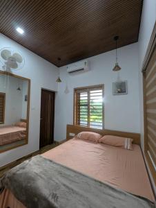 a bedroom with a large bed and a mirror at Vayalil Homestay in Karuvārakundu