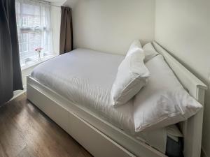 a bed with white sheets and pillows in a room at Apartment Two - Uk49592 in Bala