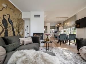 ein Wohnzimmer mit Couch und ein Esszimmer in der Unterkunft Südwind's Greta & Sylt in Sylt + 34 Fotos