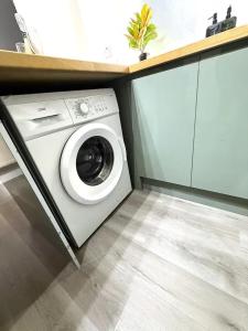 a white washing machine in a kitchen with a counter at Stylish 3BR 18mins to Peak District,Free, Parking Wifi,Netflix ,Sky Sports in Ashton under Lyne