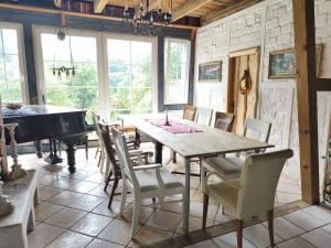 a dining room with a table and a piano at Ferienwohnung Sieg in Mittelhof +4 photos