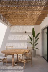 Un comedor con mesa y sillas de madera. en Villa Victoria El Roque, en Roque