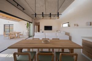 comedor y sala de estar con mesa de madera y sillas en Villa Victoria El Roque, en Roque