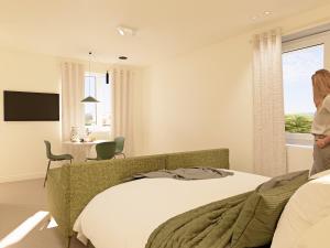 een vrouw in een slaapkamer met een bed bij Hilltop Haven in Torquay