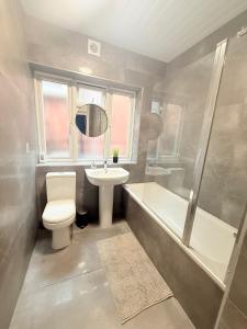 a bathroom with a toilet and a sink and a tub at 5 minutes to Wembley Rooms in London +36 photos