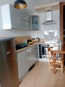 cocina con electrodomésticos de acero inoxidable y mesa de madera en Studio montagne, en Tignes