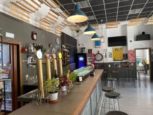 a bar in a restaurant with a counter and stools at El Vagón Bar-Albergue Béjar in Béjar