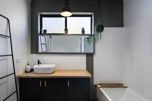 a bathroom with a sink and a mirror at The Bach- dog friendly with lovely bush views in Hepburn +10 photos