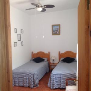 a bedroom with two beds and a ceiling fan at Casa Ramona in Valencia +12 photos