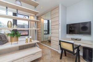 Trendy Foreshore Studio Fully Equipped and Central في كيب تاون: غرفة معيشة مع مكتب وتلفزيون وكرسي