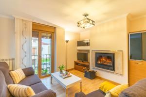 a living room with a couch and a fireplace at Acogedor apartamento rodeado de naturaleza in Lerate