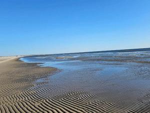 a beach with ripples in the sand and water at 7 person holiday home in Fanø-By Traum in Fanø