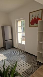 an empty kitchen with a refrigerator and a door at Maison au calme dans la Drôme in Saulce-sur-Rhône