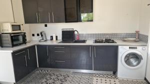 a kitchen with a sink and a washing machine at Maison au calme dans la Drôme in Saulce-sur-Rhône +4 photos