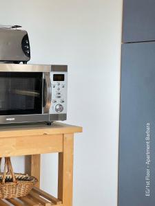 a microwave sitting on a table next to a refrigerator at Ferienwohnung Barbara in Oberammergau