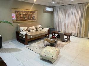 a living room with a couch and a table at OSIF Chic City Retreat in Yaoundé