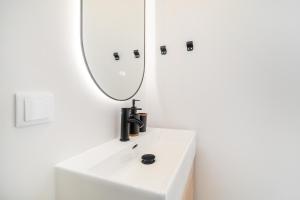 Un baño con un lavabo blanco y un espejo. en WHome Relaxed Stay in Central Oeiras, en Oeiras