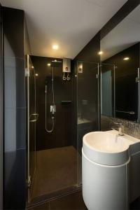 un bagno con lavandino e doccia in vetro di BTS Thonglor Skyline Condo a Bangkok