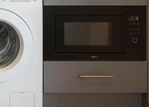 un microonde e una lavatrice sono uno accanto all'altro di BTS Thonglor Skyline Condo a Bangkok Altre 8 foto