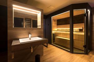 a bathroom with a sink and a tub with a mirror at Ferienhaus SUNFLOWER am Hainer See in Kahnsdorf +18 photos