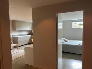 a room with a bed and a kitchen with a door at Apartment in central Mölnlycke! in Mölnlycke