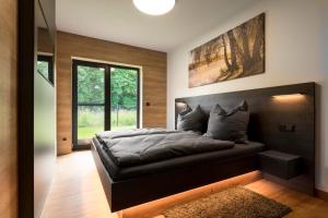 a bedroom with a large bed with a large window at Ferienhaus SUNFLOWER am Hainer See in Kahnsdorf