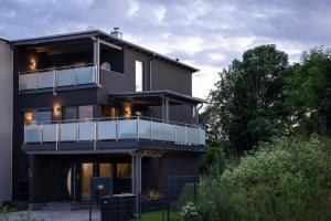 a black house with a balcony and trees at Ferienhaus SUNFLOWER am Hainer See in Kahnsdorf