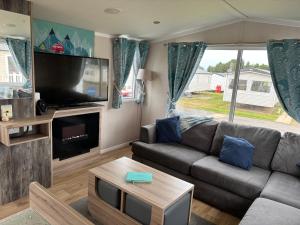 a living room with a couch and a flat screen tv at The Lay By in Prestonpans