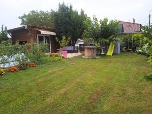 a yard with a house and a backyard with a playground at Appartement 1 chambre in Jayat