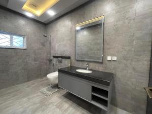 a bathroom with a sink and a toilet and a mirror at Comfort Home in DHA Phase 9 Lahore in Lahore