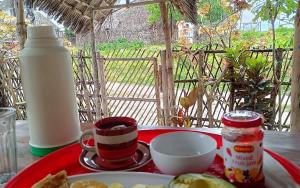 Una mesa con un plato de comida y una botella de leche. en Hakuna Matata Bungalows, en Jambiani