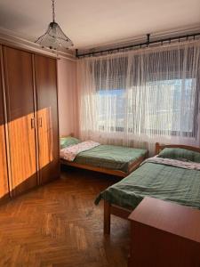 a bedroom with two twin beds and a window at Smestaj za radnike Šabac-Štitar Gačić in Štitar