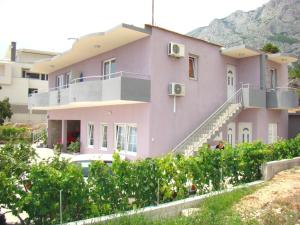 a pink house with a balcony on a hill at Apartment Mativa in Makarska
